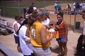 Kelley Pastic looks onto the field to get more autographs